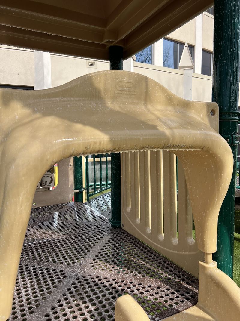 A playground climbing frame, dull with grime
