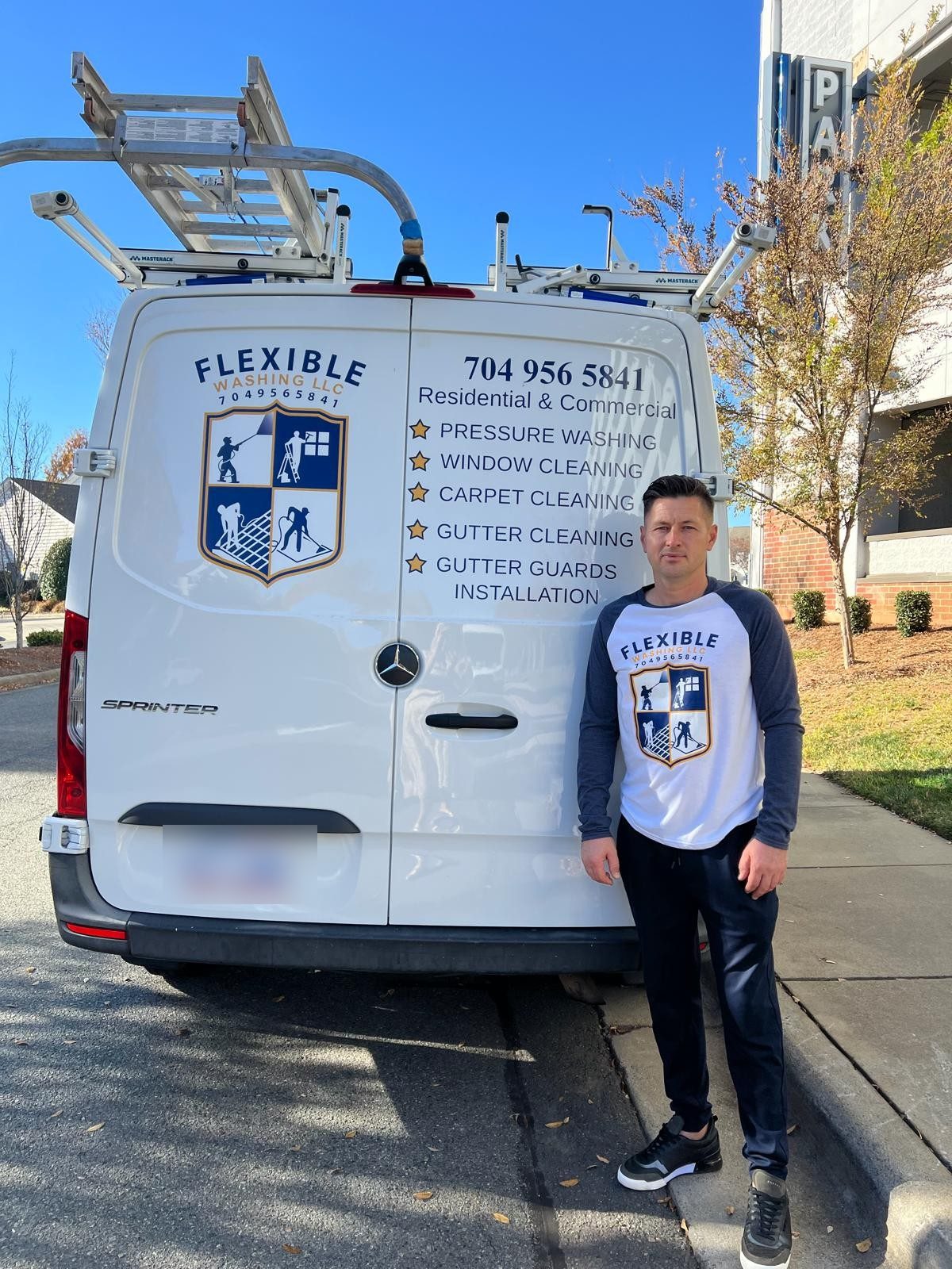 One of the owners of Flexible Washing beside the company van, the crest on its doors and on his shirt